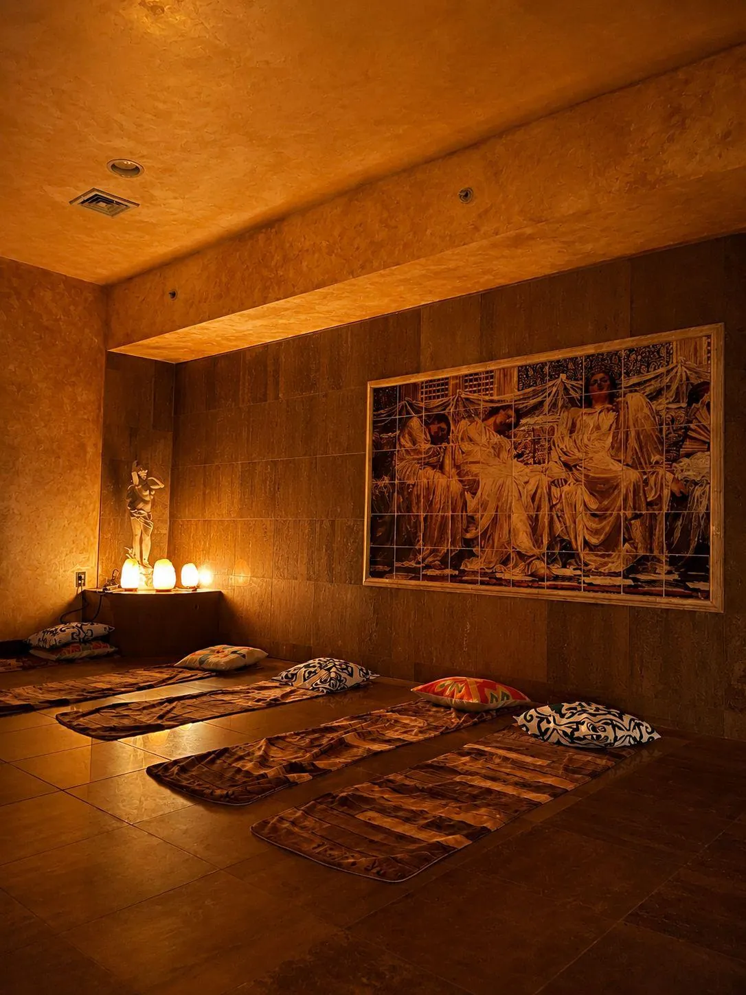 BRC's relaxation room: mats on the heated floor, salt lamps glowing and a tiled mural on the wall.