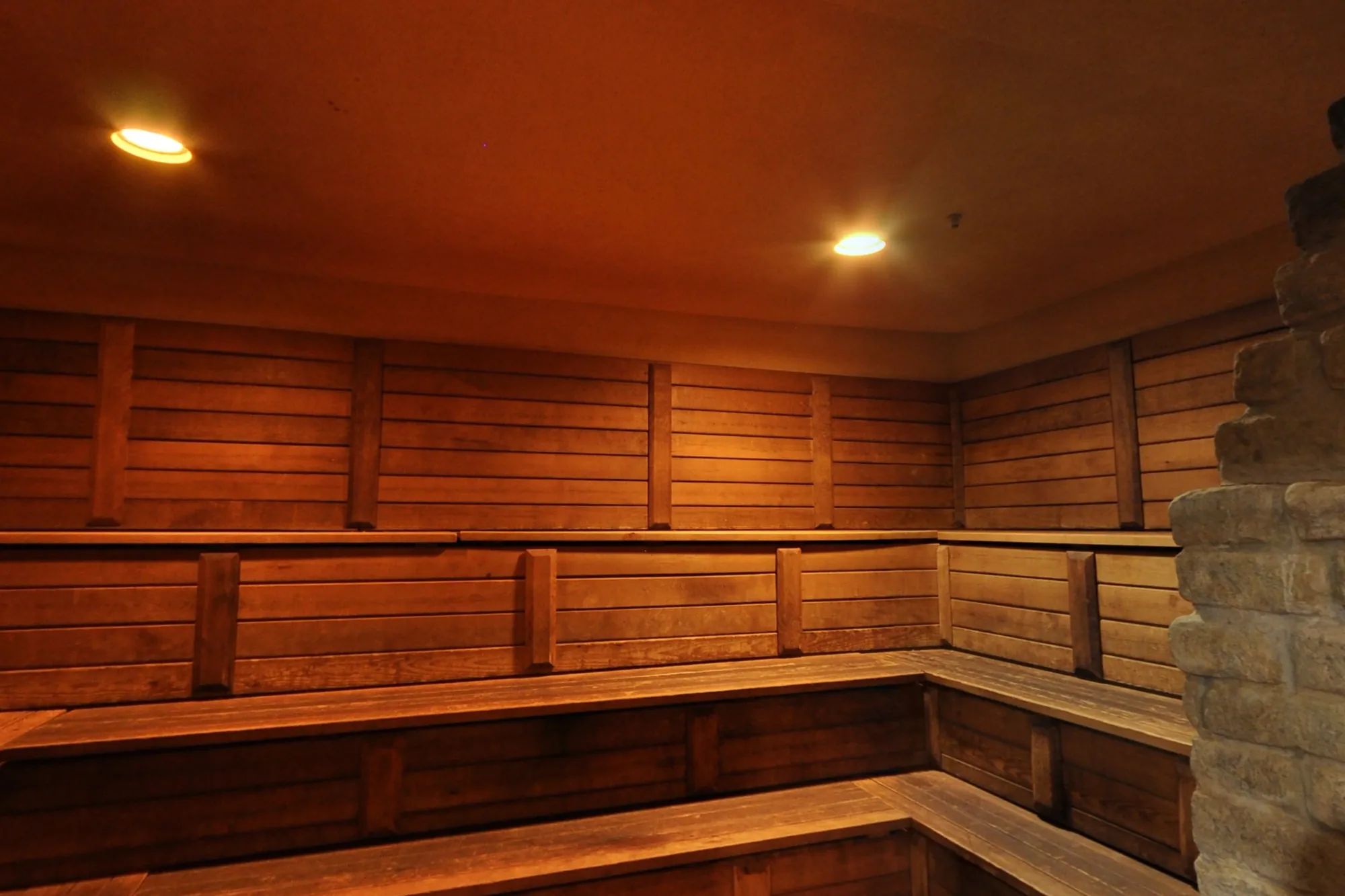 The tiered cedar benches of BRC's Russian dry sauna, lit warm.