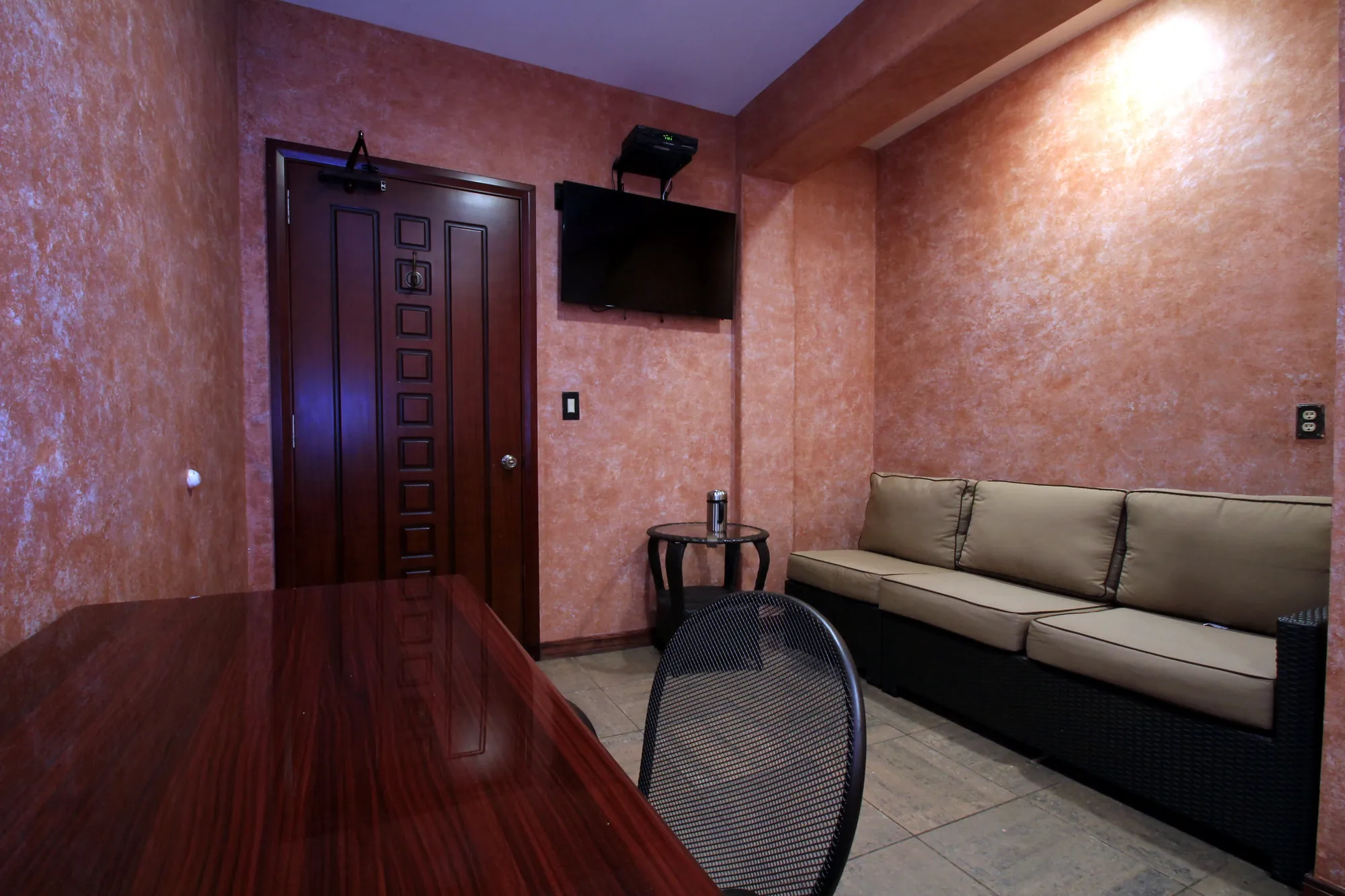 The regular private room: two couches, a table and a television, walls in warm plaster.